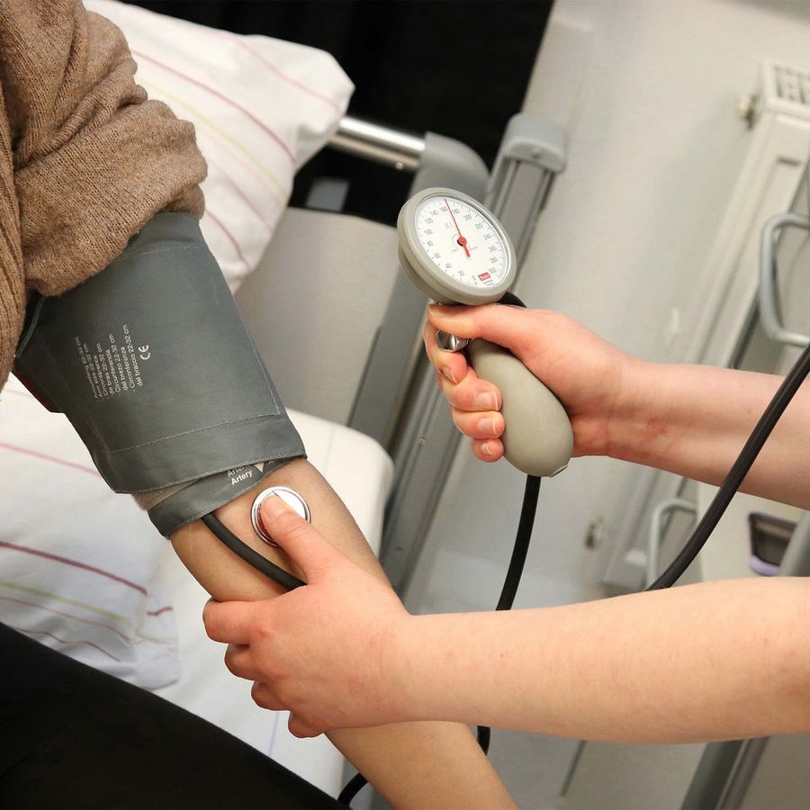Pflegefachkraft misst einer Patientin den Blutdruck – Behandlungspflege nach ärztlicher Verordnung