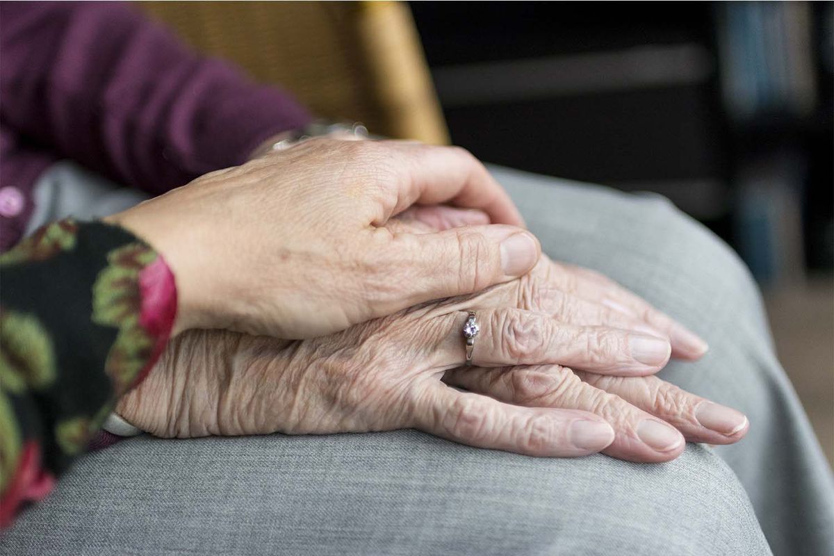 Pflegekraft hält behutsam die Hand einer Seniorin – Grundpflege und Aktivierungspflege zuhause